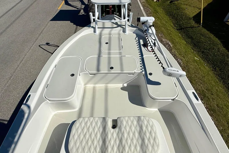 Slide: The Image of 2024 Shallow Sport 24 Modified V boat deck with storage compartments and trolling motor. - 13
