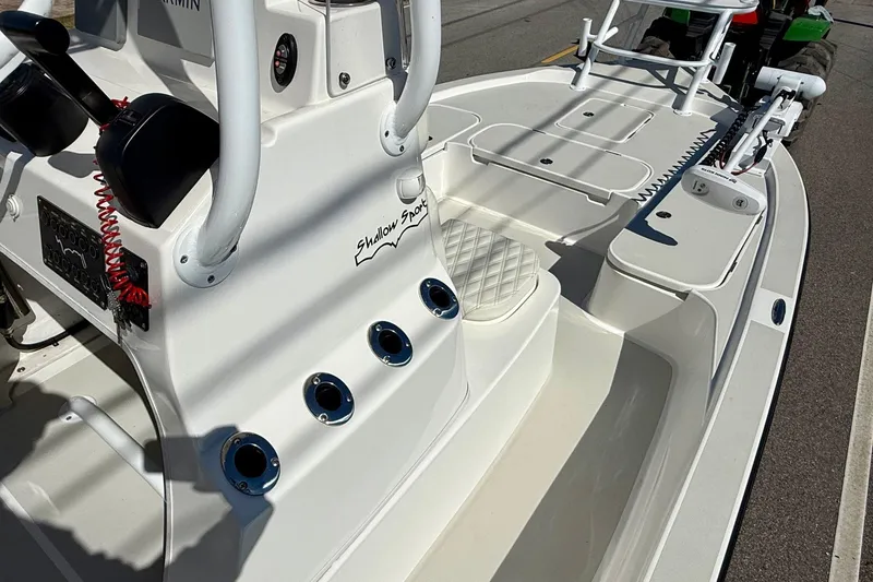 Slide: The Image of 2024 Shallow Sport 24 Modified V boat interior with fishing rod holders and control panel. - 14