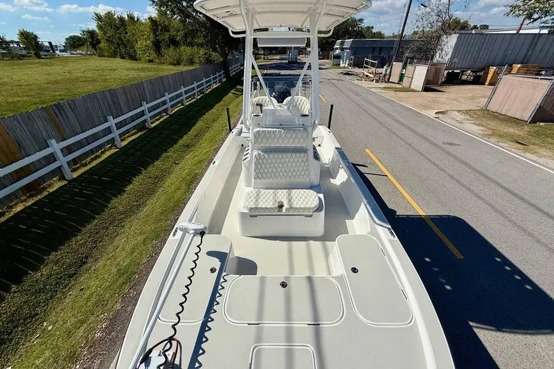 Slide: The Image of 2024 Shallow Sport 24 Modified V boat on a road, showcasing spacious deck and seating. - 15