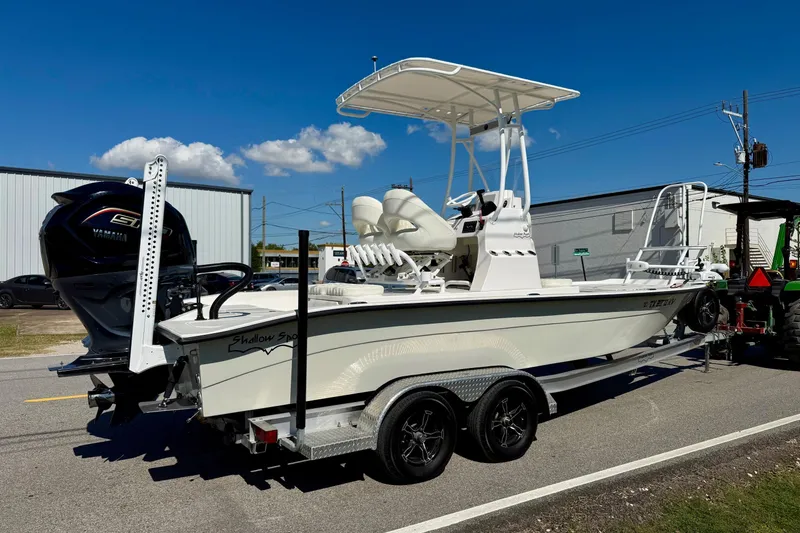 Slide: The Image of 2024 Shallow Sport 24 Modified V boat on trailer, featuring Yamaha engine, under clear blue sky. - 4
