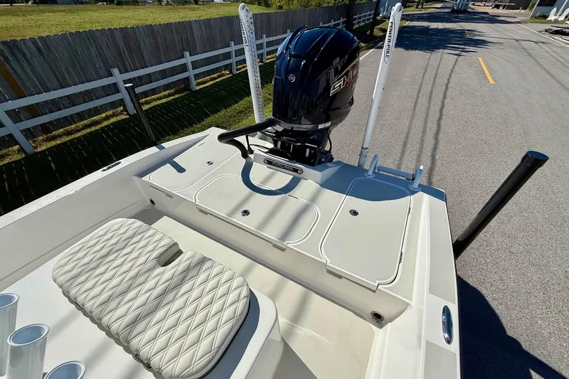 Slide: The Image of 2024 Shallow Sport 24 Modified V boat with outboard motor and cushioned seating. - 7