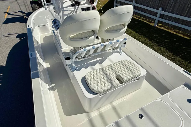 Slide: The Image of 2024 Shallow Sport 24 Modified V boat interior with white seating and rod holders. - 8