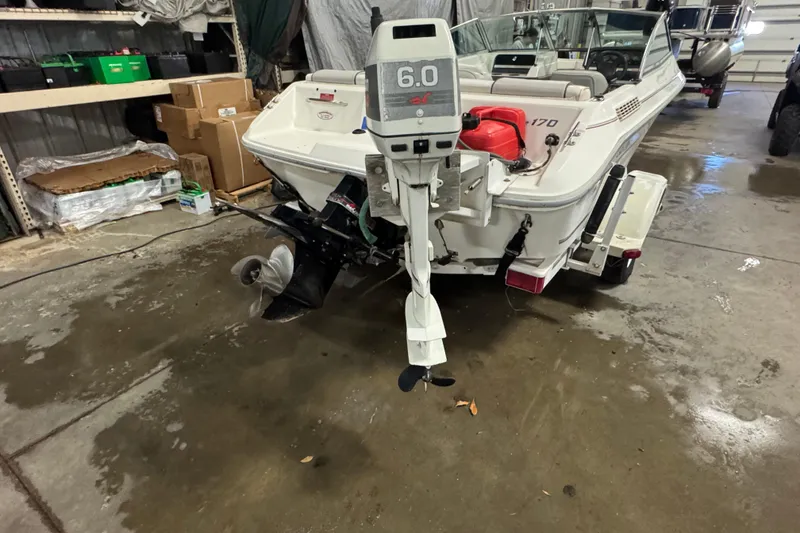 Slide: The Image of 1993 Sea Ray 170 Bow Rider in garage, showcasing outboard motor and interior. - 4