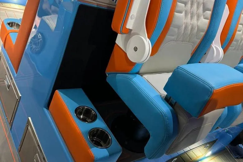 Slide: The Image of 2025 Cigarette 52 Thunder interior with vibrant blue and orange seating, featuring cup holders. - 9