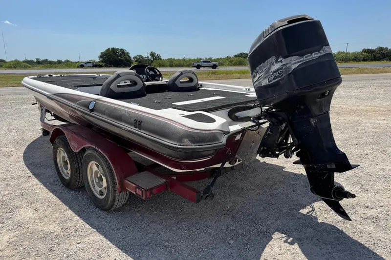 Slide: The Image of 2000 Triton TR-21 boat with dual axle trailer and outboard motor in a parking area. - 2