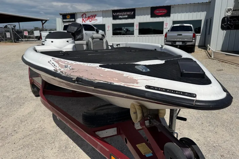 Slide: The Image of 2000 Triton TR-21 boat with visible hull damage on a trailer. - 5