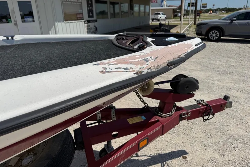Slide: The Image of Damaged 2000 Triton TR-21 boat on trailer, showing wear and scratches. - 6