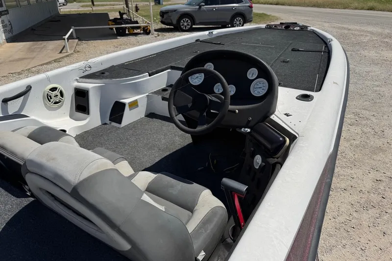 Slide: The Image of 2000 Triton TR-21 boat interior with steering wheel and gauges, parked outdoors. - 8