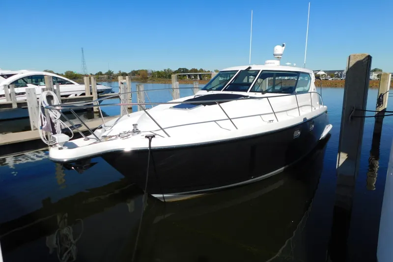 The Image of 2009 Tiara Yachts 4300 Sovran docked in a marina under clear blue skies. - 1