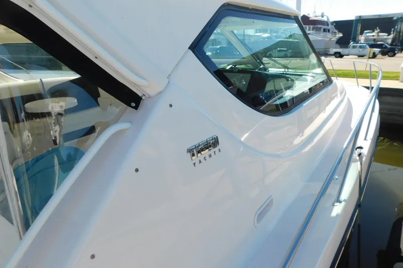 Slide: The Image of 2009 Tiara Yachts 4300 Sovran, sleek white exterior with logo, docked in marina. - 10