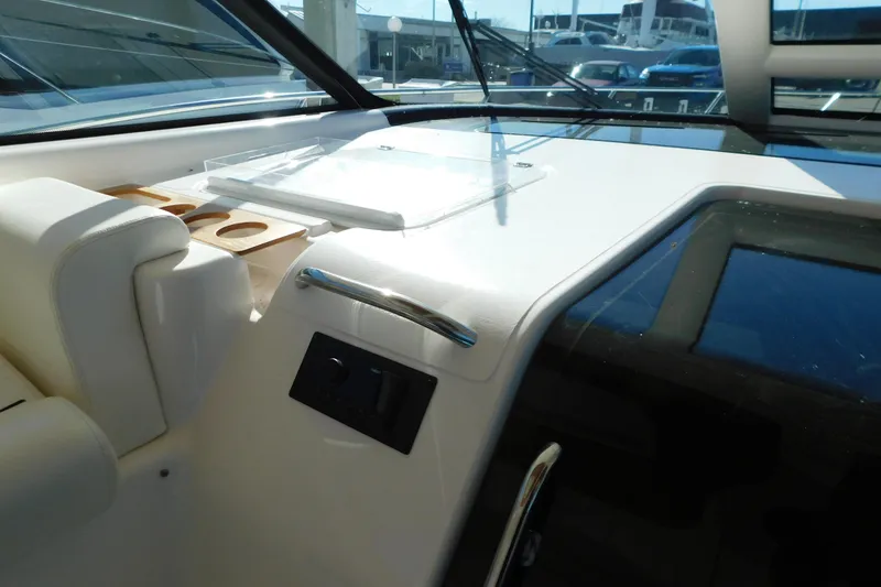 Slide: The Image of 2009 Tiara Yachts 4300 Sovran helm station with controls and cup holders. - 25
