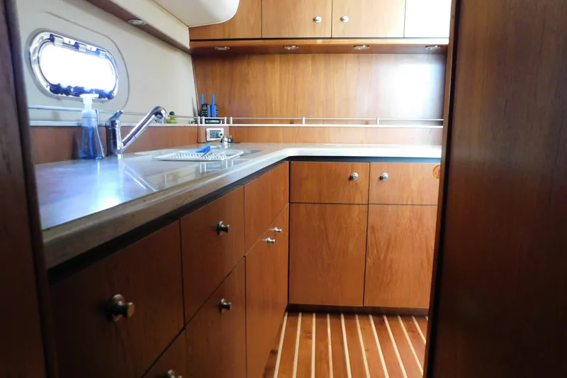 Slide: The Image of 2009 Tiara Yachts 4300 Sovran galley with wooden cabinets and modern fixtures. - 38