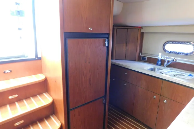 Slide: The Image of 2009 Tiara Yachts 4300 Sovran interior kitchen with wooden cabinets and stainless steel sink. - 39
