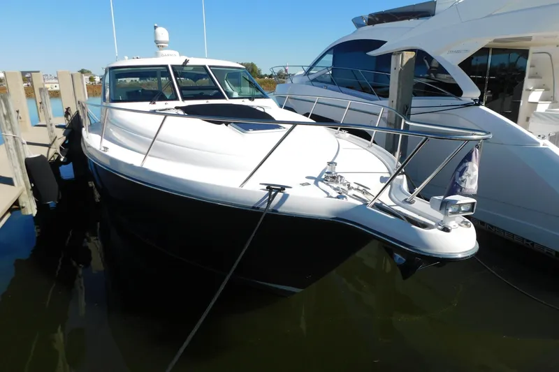 Slide: The Image of 2009 Tiara Yachts 4300 Sovran docked at marina, sleek design, sunny day. - 4