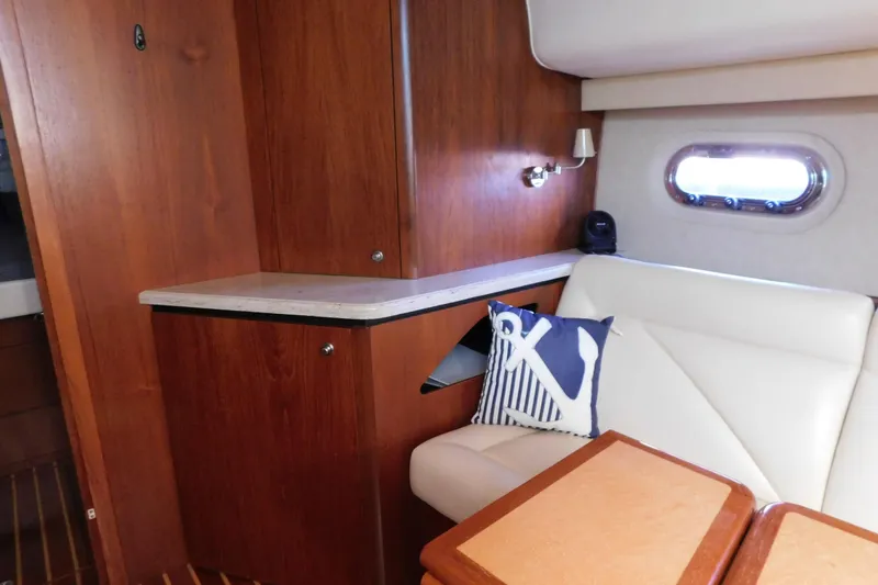 Slide: The Image of 2009 Tiara Yachts 4300 Sovran interior with wood cabinetry and white seating. - 42