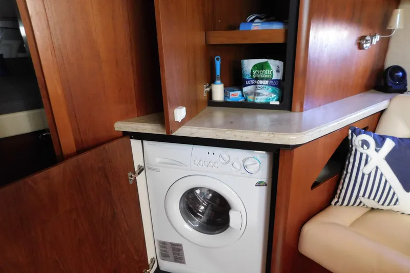 Slide: The Image of 2009 Tiara Yachts 4300 Sovran interior with washer, wooden cabinetry, and nautical-themed decor. - 44