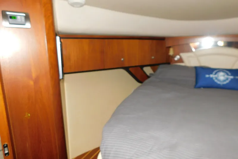 Slide: The Image of 2009 Tiara Yachts 4300 Sovran cabin interior with wood paneling and bed. - 46