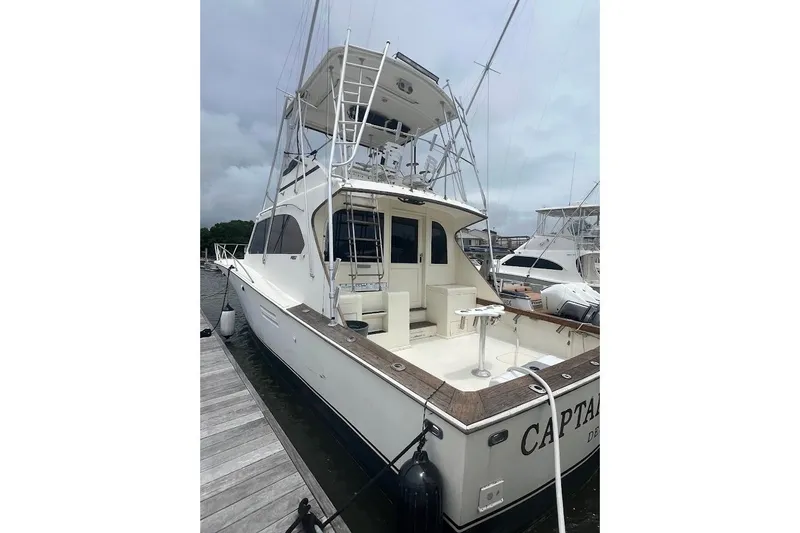 Slide: The Image of 1988 Post 46 ll yacht docked at marina, featuring spacious deck and fishing equipment. - 21