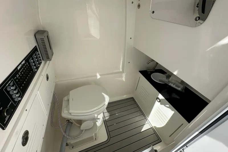 Slide: The Image of 2026 Sea Pro 292 Offshore boat bathroom with toilet, sink, and control panel. - 12