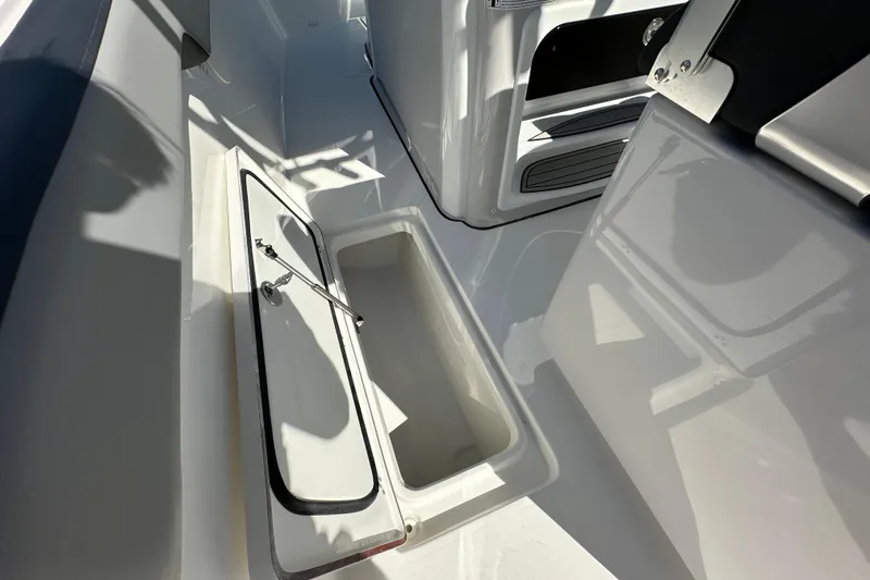 Slide: The Image of 2026 Sea Pro 292 Offshore boat interior storage compartment, open lid, white finish. - 16