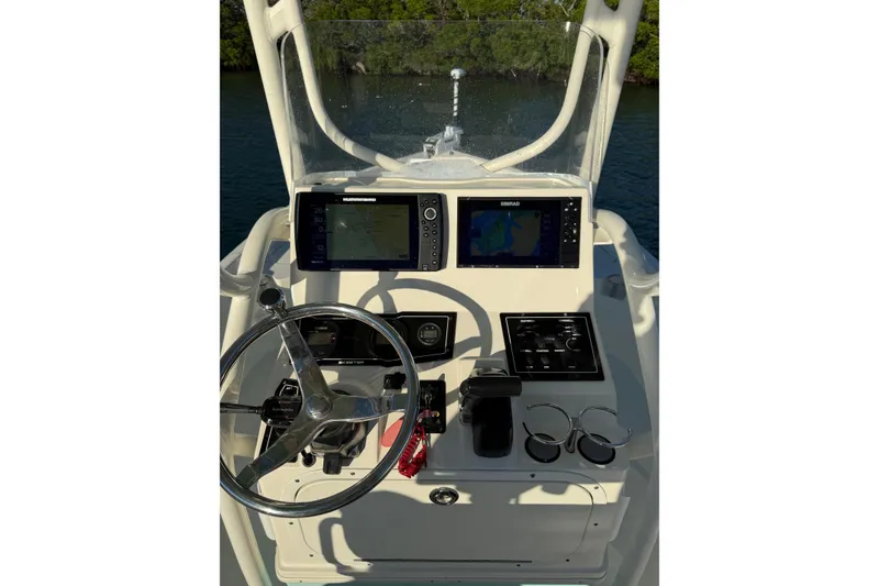 Slide: The Image of 2017 Skeeter SX230 boat dashboard with steering wheel and navigation screens. - 12