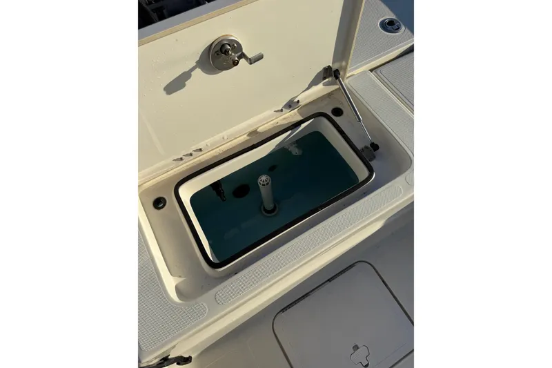 Slide: The Image of 2017 Skeeter SX230 boat livewell with open lid, showcasing interior features. - 15