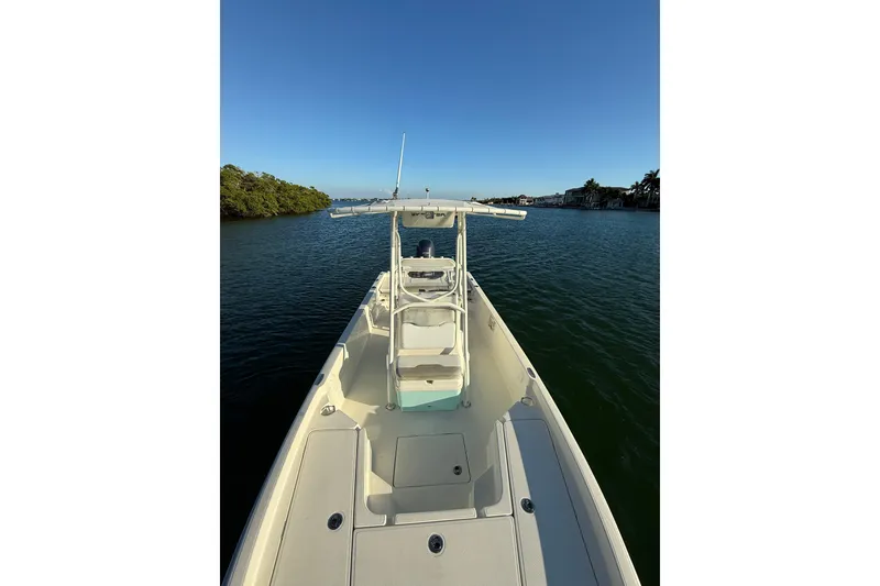 Slide: The Image of 2017 Skeeter SX230 boat on calm water, clear sky, and scenic shoreline. - 21