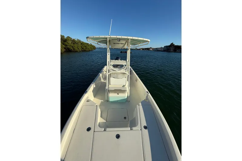 Slide: The Image of 2017 Skeeter SX230 boat on calm water, featuring a spacious deck and T-top. - 22