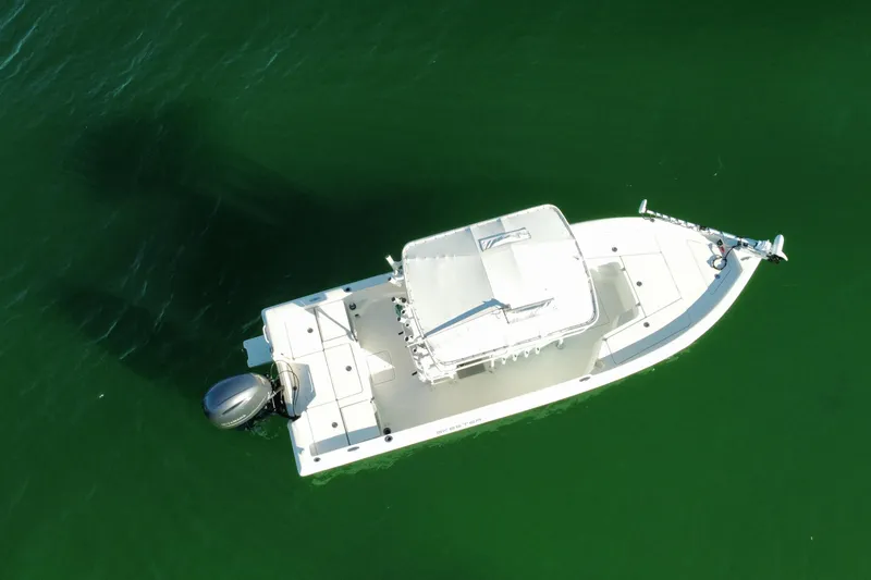 Slide: The Image of 2017 Skeeter SX230 boat on calm water near a sandy beach with trees. - 3