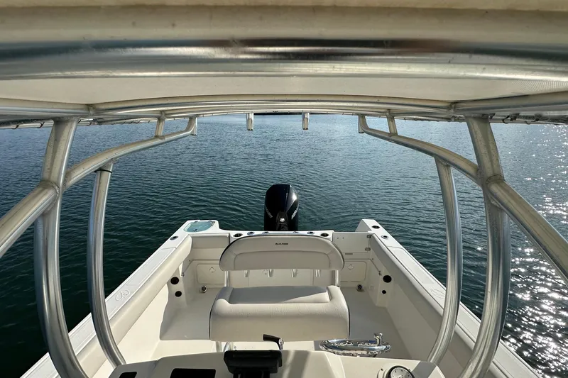 Slide: The Image of 2022 Sailfish 242 CC boat interior with ocean view, featuring seating and motor. - 10