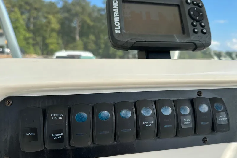 Slide: The Image of Control panel of 2022 Sailfish 242 CC boat with Lowrance display and switches. - 13
