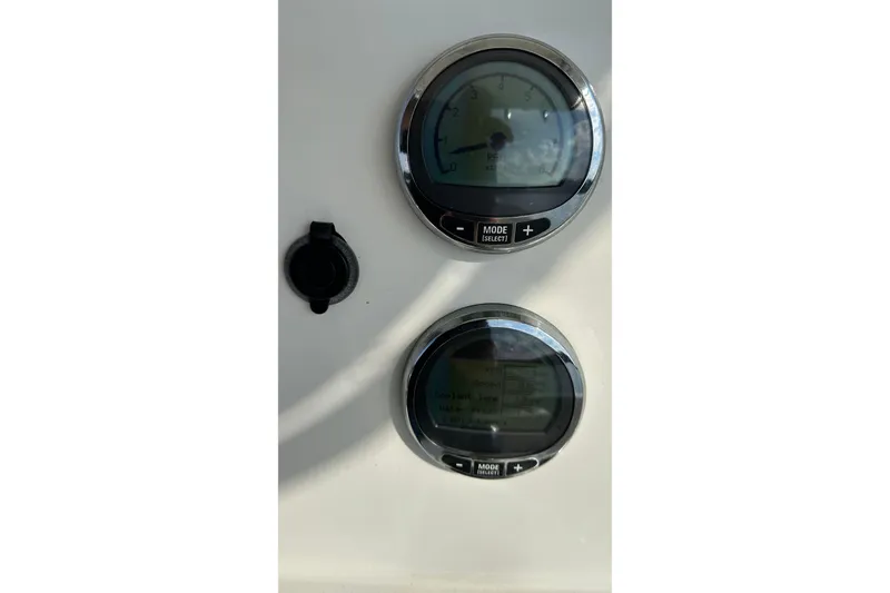 Slide: The Image of Close-up of 2022 Sailfish 242 CC boat gauges and controls. - 14