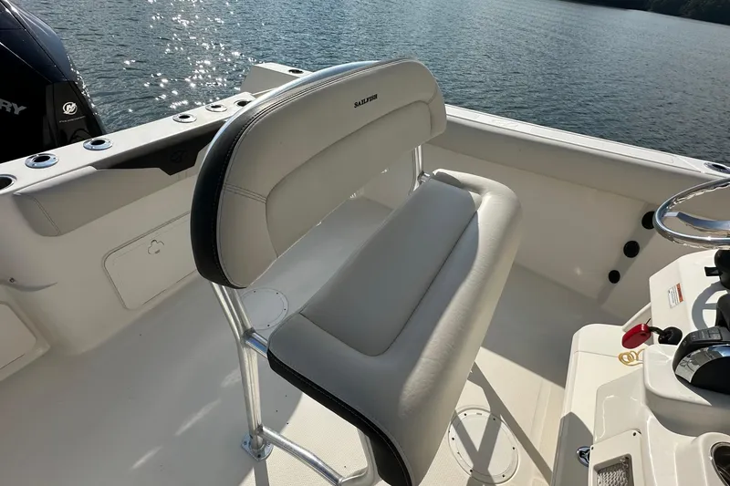 Slide: The Image of 2022 Sailfish 242 CC boat interior with cushioned seating and steering wheel. - 7