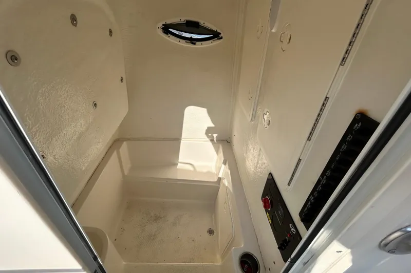 Slide: The Image of 2022 Sailfish 242 CC interior compartment with control panel and porthole. - 13