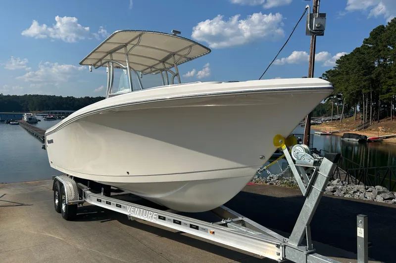 Slide: The Image of 2022 Sailfish 242 CC boat on trailer by a lake under a clear sky. - 15