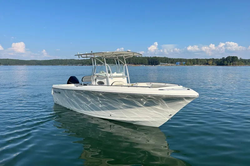 Slide: The Image of 2022 Sailfish 242 CC boat on calm lake with clear blue sky. - 18