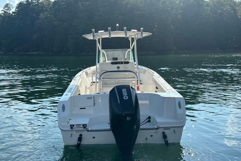 Slide: The Image of 2022 Sailfish 242 CC boat on calm water with forested background. - 4