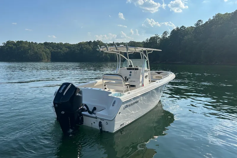 Slide: The Image of 2022 Sailfish 242 CC boat on a serene lake with clear skies. - 5