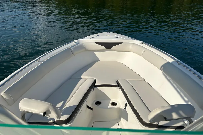 Slide: The Image of 2022 Sailfish 242 CC boat interior with cushioned seating on calm water. - 8