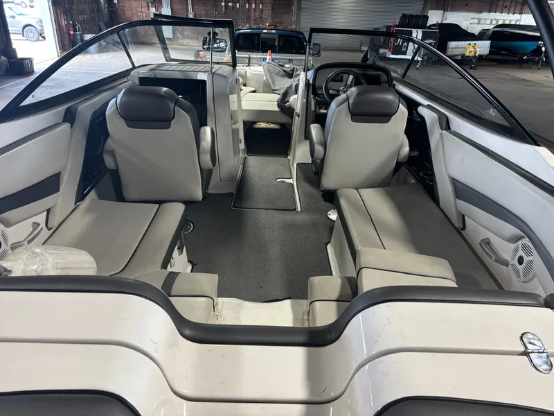 Slide: The Image of 2020 Yamaha Boats AR240 interior with seating and steering wheel in a warehouse setting. - 4