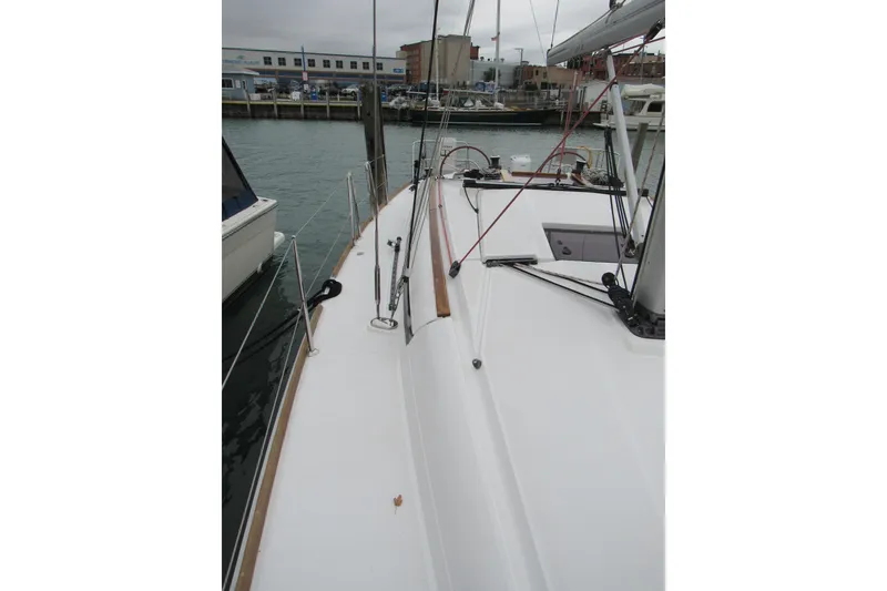 Slide: The Image of 2013 Jenneau Sun Odyssey 379 sailboat docked at marina, showcasing deck and rigging. - 12