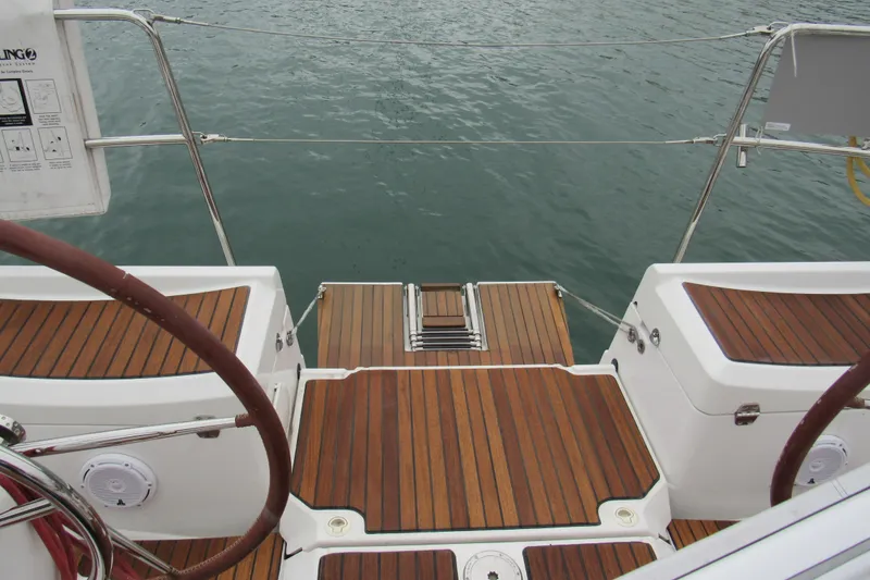 Slide: The Image of 2013 Jenneau Sun Odyssey 379 yacht deck with wooden finish, overlooking calm water. - 16