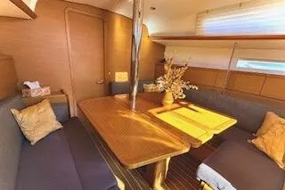 Slide: The Image of 2013 Jenneau Sun Odyssey 379 interior with cozy seating and wooden table. - 23