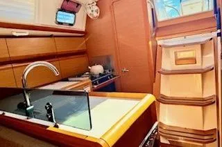 Slide: The Image of 2013 Jenneau Sun Odyssey 379 yacht interior with modern kitchen and wooden cabinetry. - 27