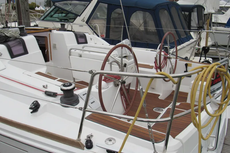 Slide: The Image of 2013 Jenneau Sun Odyssey 379 sailboat cockpit with dual steering wheels and teak flooring. - 3