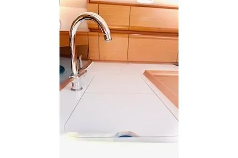 Slide: The Image of 2013 Jenneau Sun Odyssey 379 yacht kitchen with sleek faucet and wooden cabinetry. - 30