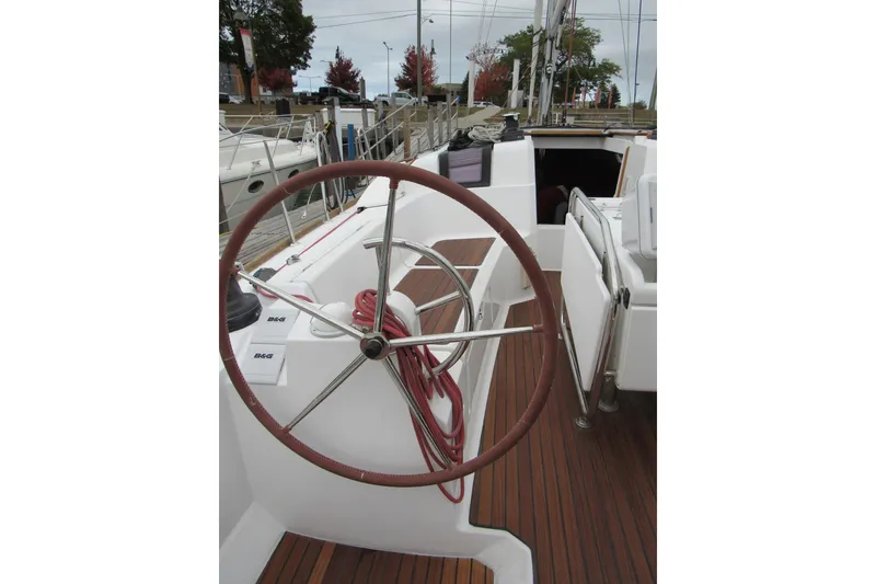Slide: The Image of 2013 Jenneau Sun Odyssey 379 sailboat cockpit with steering wheel and wooden deck. - 8
