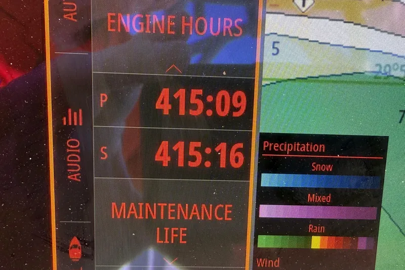 Slide: The Image of Display screen showing engine hours and weather data on a 2021 Costa Custom Boats 264 HC. - 17