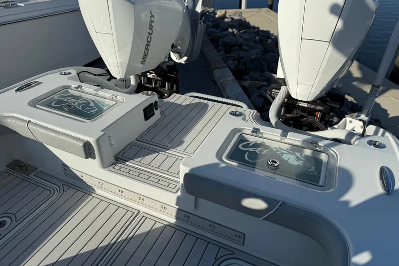 Slide: The Image of 2021 Costa Custom Boats 264 HC deck with dual Mercury engines and storage compartments. - 21