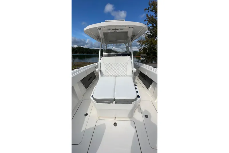 Slide: The Image of 2022 Fountain 38 CC LS boat interior with white seating and clear sky background. - 12